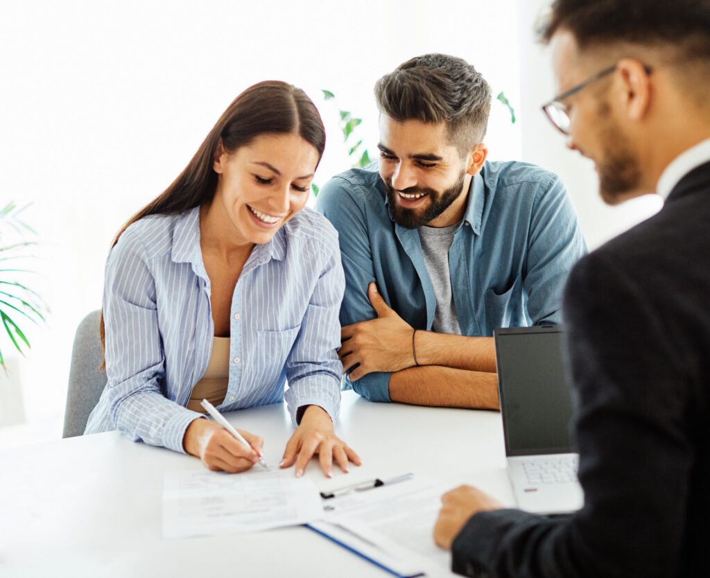 Real,Estate,Agent,With,Couple,Closing,A,Deal,And,Signing