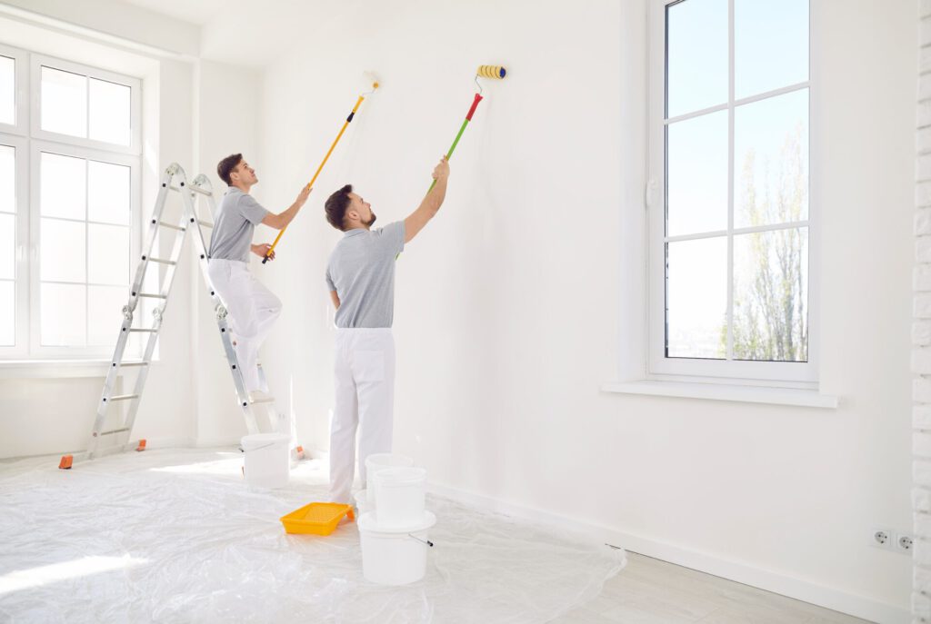 Male,Painters,Or,Construction,Workers,Painting,Walls,In,White,Color